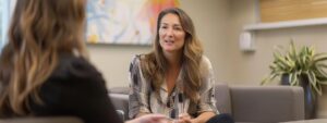 a focused portrait of a licensed dbt therapist engaging thoughtfully with a client in a modern, minimalist therapy office, illuminated by soft, ambient lighting that enhances the intimate atmosphere of their session.